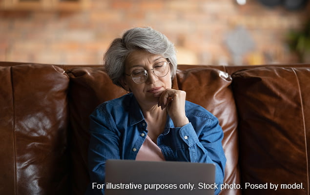 سيدة تقرأ على الكمبيوتر المحمول